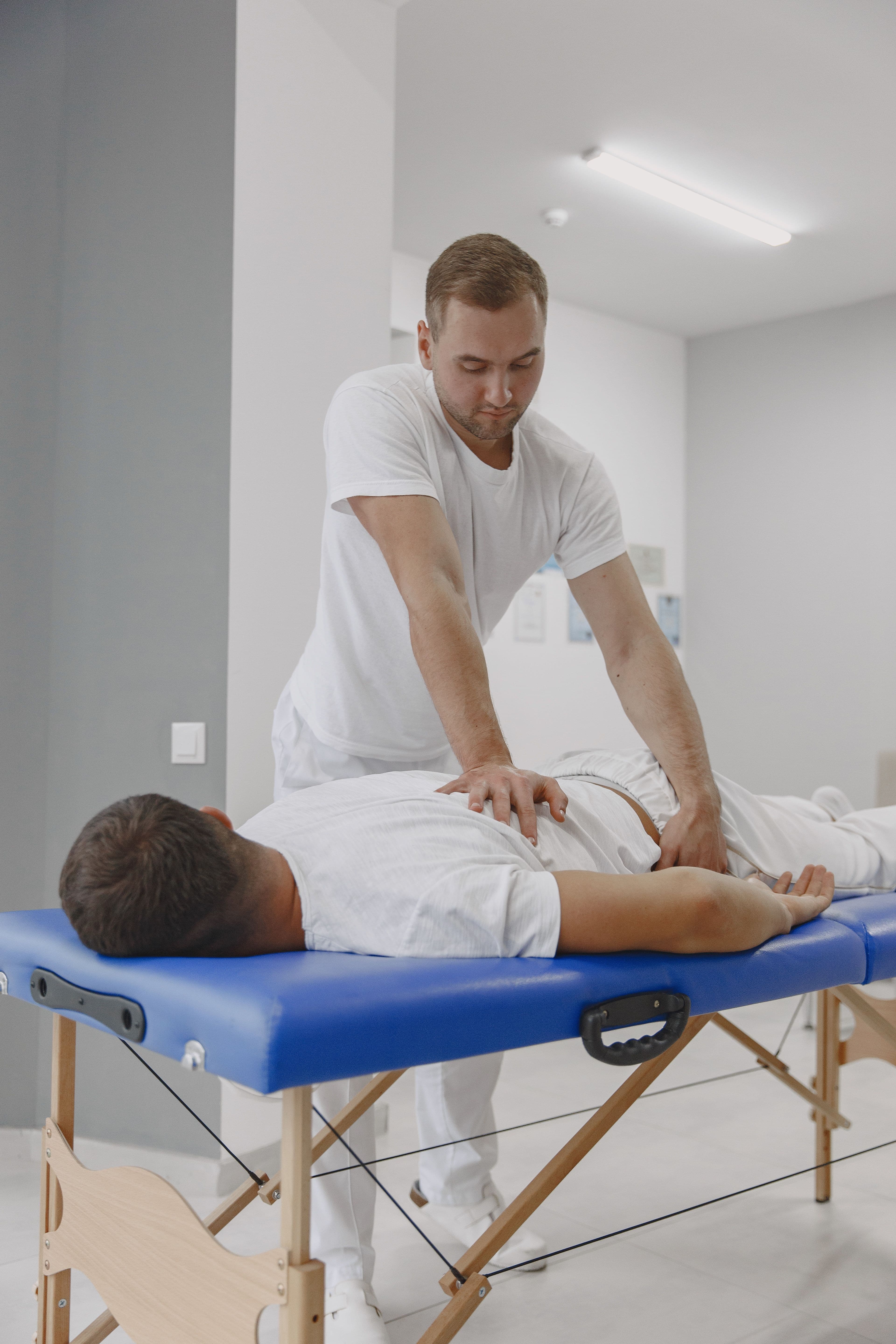 A physiotherapist applying kinesiology tape to a patient's shoulder